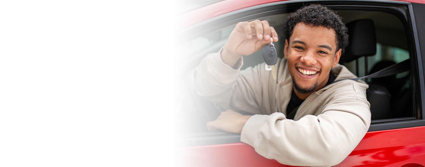 Teen boy shows off car keys, learning to drive behind the wheel of car